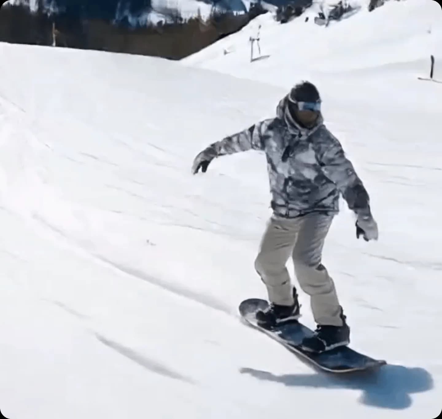 Snowboarder riding down a snowy slope